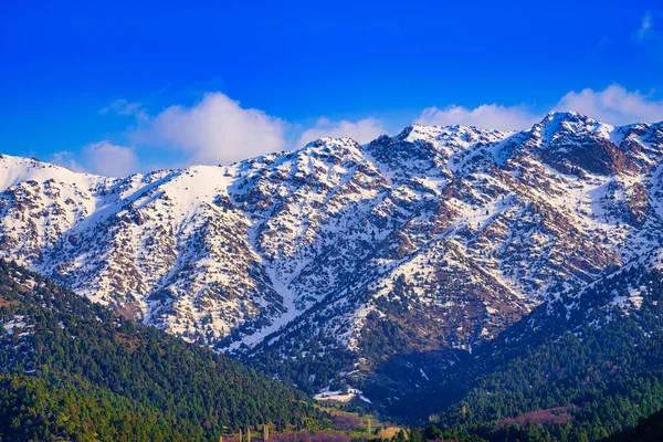 Mountain top covered with young snow and illuminated by the sun on a sunny spring day. Mountain landscape.