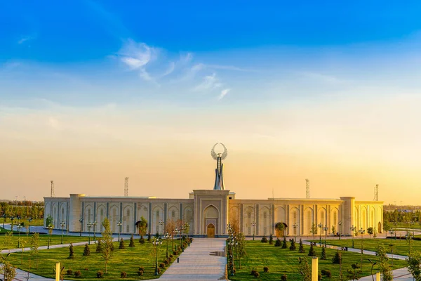 stock image UZBEKISTAN, TASHKENT - APRIL 25, 2023: The territory of the park New Uzbekistan with Monument of Independence in the form of a stele with a Humo bird at twilight in spring.