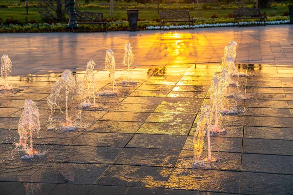 Маленькие Фонтаны Тротуаре Освещенные Солнечным Светом Закате Восходе Солнца Парке — стоковое фото