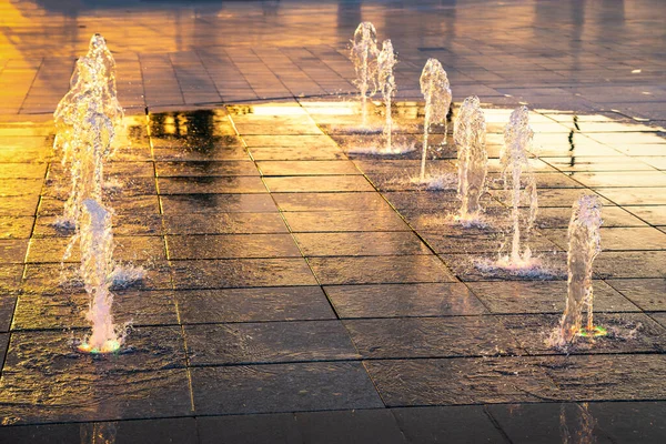 歩道には小さな噴水があり 日没や夏の公園の日の出に照らされています — ストック写真