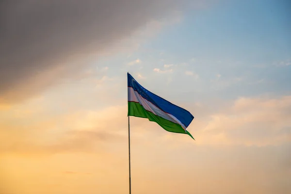 Flagge Usbekistans Weht Bei Sonnenuntergang Oder Sonnenaufgang Dramatischer Bewölkter Himmel — Stockfoto