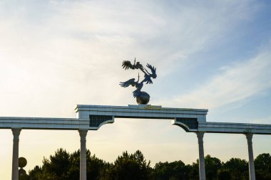 Taşkent 'teki Independence Meydanı' ndaki Bağımsızlık Anıtı bulutlu gökyüzüyle gün batımında aydınlandı.