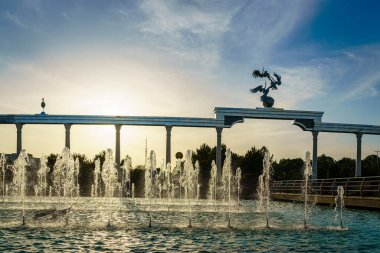 Günbatımında gün batımında gün batımında ya da yazın Bağımsızlık Meydanı 'nda, Taşkent, Özbekistan' da gün ışığıyla aydınlanan çeşmeler ve anıtlar..