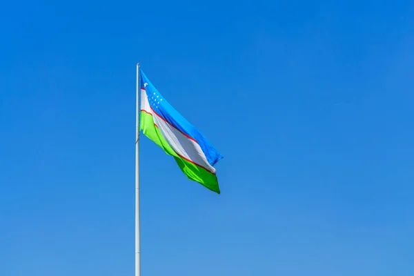 Vlag Van Oezbekistan Zwaaiend Een Blauwe Lucht Achtergrond Overdag — Stockfoto
