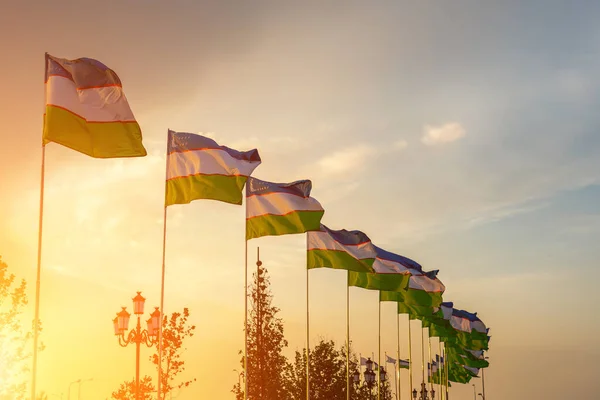 Banderas Uzbekistán Ondeando Sobre Atardecer Amanecer Dramático Cielo Nublado Fondo — Foto de Stock