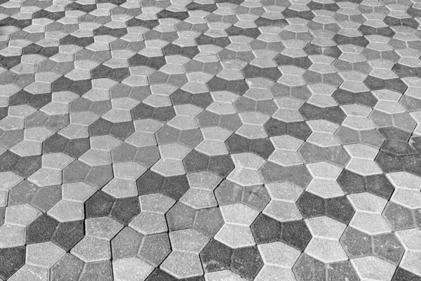 stock image The texture of a stone old monotonous pavement with a perspective. Abstract background. Black and white.