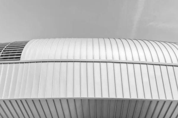 stock image Black and white fragment of a modern building covered with metal aluminum panels.