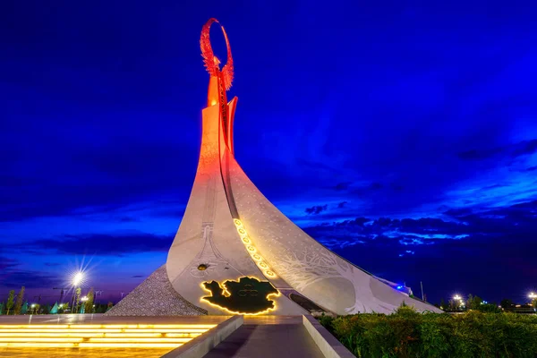 stock image UZBEKISTAN, TASHKENT - AUGUST 15, 2023: Illuminated monument of independence in the form of a stele with a Humo bird in the New Uzbekistan park at nighttime in summertime.