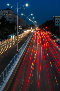 Otobanda hareket halindeki araba farları ve geceleri şehrin sokak lambaları. Bulanık araba hareketi.