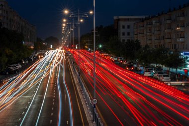 Otobanda hareket halindeki araba farları ve geceleri şehrin sokak lambaları. Bulanık araba hareketi.