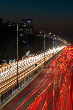 Otobanda hareket halindeki araba farları ve geceleri şehrin sokak lambaları. Bulanık araba hareketi.