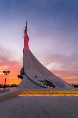 UZBEKISTAN, TASHKENT - 15 Eylül 2023: Yeni Özbekistan parkında dramatik bir kliodi gökyüzü ile alacakaranlıkta bir Humo kuşuyla birlikte bir çelik şeklinde Bağımsızlık Anıtı.