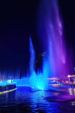 Özbekistan, Taşkent - 27 Eylül 2023: Taşkent City Parkı 'nda gece vakti lazer aydınlatma ve hafif müzikli bir çeşme.
