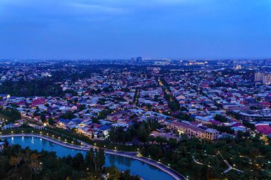 Özbekistan, Taşkent - 29 Eylül 2023: Taşkent TV kulesindeki gözlem güvertesinden şehrin gece vakti sisle kaplı merkez kısmına kadar en iyi görüntü. Şehirde hava saldırısı.