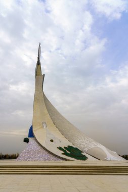 Tahkent, Özbekistan - 17 Ekim 2023: Sonbaharda Yeni Özbekistan parkında bulutlu bir günde bir Humo kuşuyla birlikte bir çelik heykel şeklinde Bağımsızlık Anıtı.