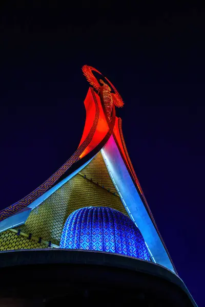 Özbekistan, Taşkent - 11 Aralık 2023: Gece vakti Yeni Yangi Özbekistan parkında bir Humo kuşuyla birlikte bir çelik heykel şeklinde aydınlatılmış.