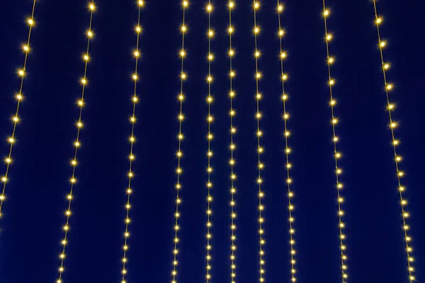 Festive hanging LED garlands against the background of the night sky. Holidays decorations.
