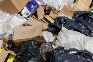 Kaluga, Rusya - 21 Kasım 2019: Plastik çöp torbaları ve karton kutular doğaya atıldı. Çevre kirliliği ve çöp konsepti. Çevresel değişim.
