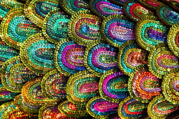 Beautiful multi-colored sequins shimmering in the light in the form of a peacock tail. Abstract background for design.