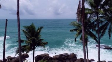 Karanlık bir denizde, okyanus yüzeyindeki kayalara akan dalgaları çarpan hava manzarası, kayalara çarpan inanılmaz deniz dalgaları, 4k 'lık okyanus manzaralı dron.