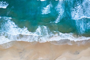 Deniz çarpan dalgaların havadan görünüşü kumsaldaki beyaz köpüklü dalgalar, deniz manzarası doğa deniz manzarası.