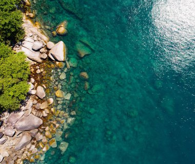 Deniz çarpan dalgaların hava manzarası. Deniz kıyısı kayaları üzerinde beyaz köpüklü dalgalar. Rocky sahili dağ manzarası.