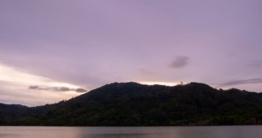 Zaman ayarlı günbatımı gökyüzü ve gölün üzerindeki bulutlar, dramatik gökyüzünde hareket eden inanılmaz bulutlar, gün batımında bulutlu doğa hızlandırılmış fırtına bulutları, doğanın güzel ışığından geceye