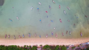Denizde uzun kuyruklu balıkçı teknelerinin yukarıdan görünüşü, aşağı doğru hareket eden insansız hava aracı kameraları, Phuket Tayland 'daki inanılmaz deniz plajları.