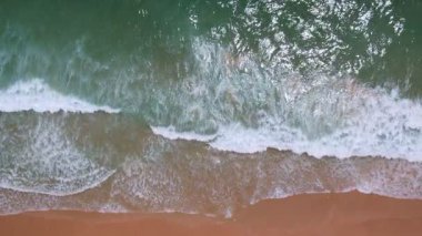 Sahilin tepesindeki dalgalar, hava manzarası denizi dalgalandırıyor. Yavaş çekimde inanılmaz okyanus, Tayland, Phuket Adası 'ndaki tropik plaj denizi. Tayland' a seyahat etmek için turistlerin uğrak yeridir.