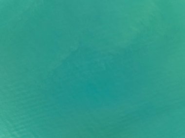 Yeşil deniz yüzeyinin en üst görüntüsü, yukarıdan çekilen açık deniz manzarası, Turkuaz su yüzeyinin inanılmaz arka planı, Güneş ışığını yansıtıyor.