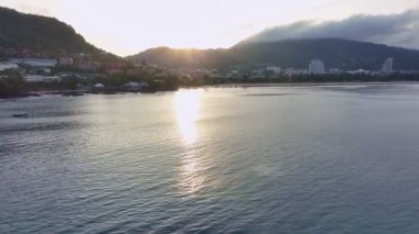 Uzun kuyruklu balıkçı tekneleri denizde güneş doğarken gökyüzünde bulutlarla Patong körfezinin üzerinde sabah Phuket Tayland 'da, yaz mevsiminde güzel deniz.
