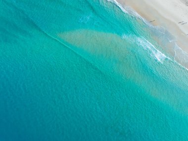 Güzel deniz dalgaları su yüzeyi, Kumsal Kum Denizi kıyısı ve dalgalar beyaz köpüklü yaz güneşli arka plan.