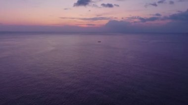 Deniz yüzeyinin üzerinde renkli gün batımı veya gün doğumu, açık denizde uçan hava aracı, su yüzeyinde güneşin güzel ışığını yansıtıyor, okyanus üzerinde gün batımı, deniz yazı ve seyahat tatili kavramı.