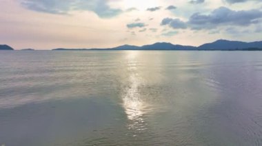 Deniz yüzeyinin üzerinde renkli gün batımı veya gün doğumu, açık denizde uçan hava aracı, su yüzeyinde güneşin güzel ışığını yansıtıyor, okyanus üzerinde gün batımı, deniz yazı ve seyahat tatili kavramı.