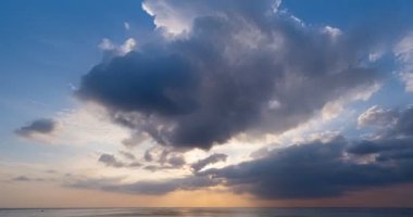 Deniz manzarası üzerinde gün batımının hızlandırılması, doğanın inanılmaz ışığı gökyüzü bulutları ve bulutlar yuvarlanıyor, renkli gün batımı ya da gün doğumunda dramatik bulutlar altın saat içinde