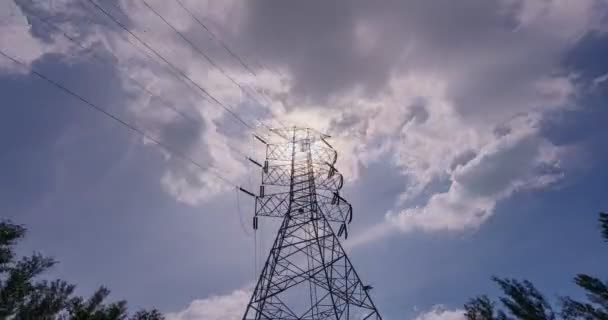 高電圧電柱線タイムラプス 青い空の背景に白い雲が流れる高電圧タワー太陽光フレア Kタイムラプスボトムビュー電柱 — ストック動画