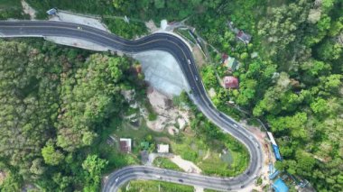 Aerial view top down drone shot above the winding mountain road between the trees rainforest,Phuket Thailand,in summer season weather, Car driving through the curve 4-K resolution