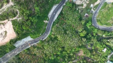 Aerial view top down drone shot above the winding mountain road between the trees rainforest,Phuket Thailand,in summer season weather, Car driving through the curve 4-K resolution