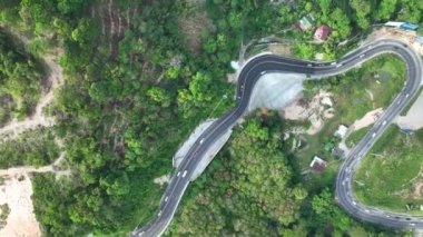 Aerial view top down drone shot above the winding mountain road between the trees rainforest,Phuket Thailand,in summer season weather, Car driving through the curve 4-K resolution