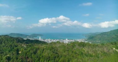 Aerial view Drone High angle view, Hyperlapse footage of patong city with high mountain in the foreground,Patong bay Phuket Thailand Beautiful nature background,High quality timelapse clouds over sea