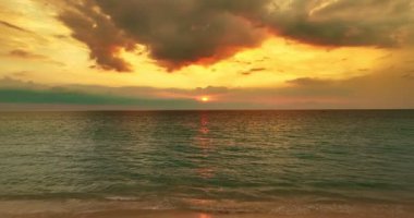 Aerial drone view fly over Tropical sea sunrise or sunset sky and ocean waves crashing on sandy beach,Golden sunset light over sea surface in the beautiful island,Amazing sea background