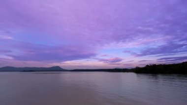 Time lapse of Majestic sunrise light over sea landscape,Amazing light of nature cloudscape sky and Clouds moving away rolling,Colorful sunset or sunrise light dramatic clouds in golden hour Footage