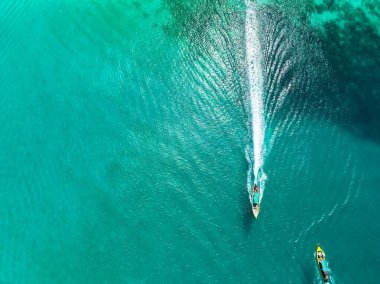 Aerial view drone top down of tourist thai longtail fishing boat in phuket islands,Amazing andaman sea in Phuket Thailand on a sunny morning with beautiful sea surface background