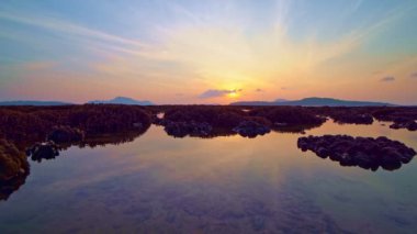 Denizde gelgit suları boyunca mercan kayalıkları tropikal adada deniz üzerinde güzel bir gün doğumu phuket thailand 'da inanılmaz manzara, şaşırtıcı deniz manzarası