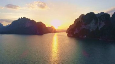 Tayland 'daki tropikal dağ zirvesinin insansız hava aracı görüntüsü, Tayland' ın güzel takımadaları Khao Sok Ulusal Parkı 'ndaki göl manzaralı dağlar, doğanın inanılmaz manzarası gün batımı veya gün doğumu zamanı.