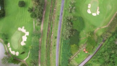 Golf sahasının havadan görünüşü yeşil çimenleri ve ağaçları golf sahasına koyuyor ve yeşil üst manzarayı yaz güneşli günlerinde golf sahalarının üzerine koyuyor.