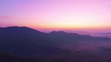 Güneşin doğuşunun havadan görünüşü, Tayland 'da sabah güneşiyle dağların doğuşu, doğanın inanılmaz manzarası, gökyüzü dramatik bulutlar sihirli anda, dağların üzerinde fantastik doğal drone zamanı.