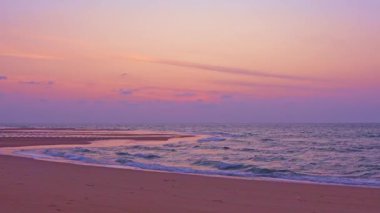 Kumsalda altın bir gün batımı, kumsalın üzerinde renkli ışık dalgalarına doğru yuvarlanan köpüklü dalgalar, kumsalda güzel bir gün batımı ya da deniz üzerinde gün doğumu, sahilde okyanus dalgaları, renkli gökyüzü.