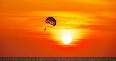 Siluet Seyahat İnsanları Parasailing deniz üzerinde gün batımının altın saatinde gökyüzüne karşı Gün batımının altın saatinde ya da gökyüzünün doğuşunda, Aktif ve aşırı eğlence