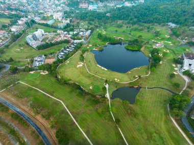 Yeşil golf sahasının yukarıdan aşağıya bakan hava aracı. Gün batımında yüksek açı görüntüsü.